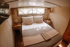 Cette petite chambre dispose d'un grand lit et d'une fenêtre. dans l'établissement Doce Lar Hostel Noronha, à Fernando de Noronha