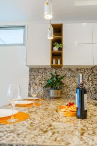 a kitchen counter with two wine glasses and a bottle at Luxury Apartments estilo New York in Guayaquil