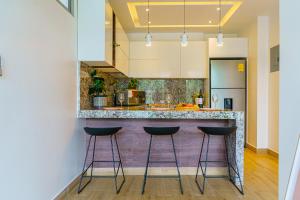 a kitchen with a counter with stools at it at Luxury Apartments estilo New York in Guayaquil