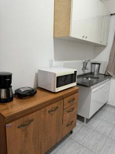 a microwave sitting on top of a counter in a kitchen at Residencial Vilaça in Guarapari