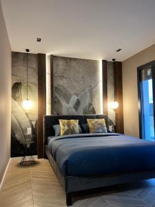 a bedroom with a blue bed with a painting on the wall at Villa Valentin 2 chambres avec jardin à Calvi in Calvi