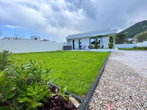 a small white house with a grass yard at Villa Valentin 2 chambres avec jardin à Calvi in Calvi +10 photos