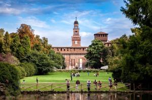 a group of people standing on a bridge in front of a building at Residenza in Palazzo d'Epoca in Milan