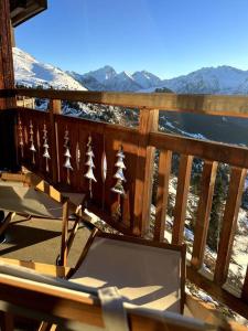 a chair on a deck with a view of the mountains at Stunning apartment with breathtaking view! in LʼHuez