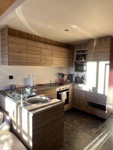 a kitchen with wooden cabinets and a sink in it at Stunning apartment with breathtaking view! in LʼHuez