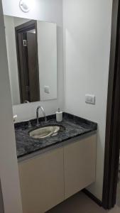 a bathroom with a sink and a mirror at N&L APARTAMENT SUIT in La Falda