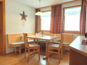 ein Esszimmer mit Tisch und Stühlen und ein Stern an der Wand in der Unterkunft Appartement Moosbrugger Haus Elisabeth in Schoppernau