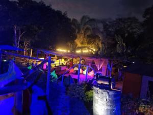 uma vista nocturna para um resort com luzes roxas em Color'Es Club em El Colegio