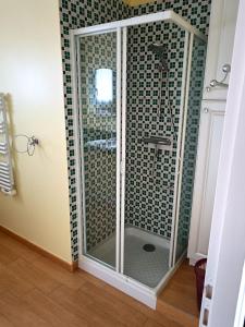 a shower with a glass door in a bathroom at Villa Victorine Omaha Beach in Saint-Laurent-sur-Mer