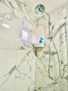 a bathroom with a shower with marble tiles at THE ROYAL BOUTIQUE STUDIO BY LONDON HEATHROW UK, PRIVATE APARTMENT OFFER's FREE PARKING, WIFI , KITCHEN & LAUNDRY SERVICES, SLEEP 6 in Hayes