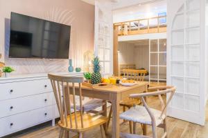 uma sala de jantar com uma mesa de madeira e cadeiras em Joyful tiny house seaside em Cabourg