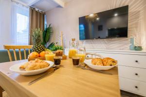 a table with two bowls of bread and orange juice at Joyful tiny house seaside in Cabourg
