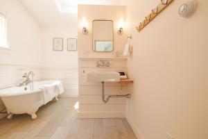 a bathroom with a sink and a tub and a mirror at 1830's Large 4BR in Heart of Acadia! [Somes Villa] in Somesville