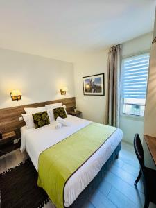 um quarto com uma cama grande e um cobertor verde em Antibes Port - Terrasse - Parking - Piscine em Antibes