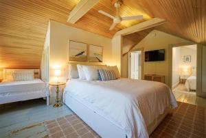 - une chambre avec un lit blanc et un ventilateur de plafond dans l'établissement 1830's Large 4BR in Heart of Acadia! [Somes Villa], à Somesville
