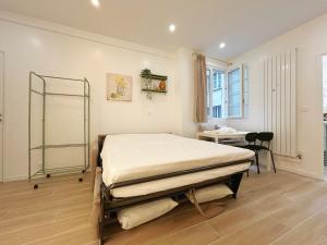 een slaapkamer met een bed, een bureau en een raam bij Cosy Louvre in Parijs