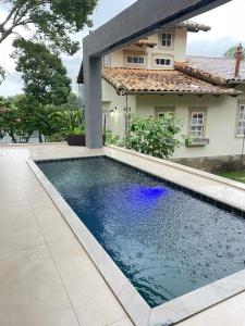 a swimming pool in front of a house at Casa Paraíso in Pirenópolis