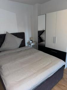 1 dormitorio con 1 cama y armario blanco en Gemütliches Appartement "Franz" in Halle, en Rusches Hof