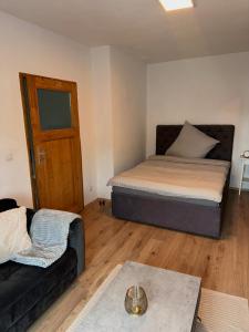 1 dormitorio pequeño con 1 cama y 1 sofá en Gemütliches Appartement "Franz" in Halle, en Rusches Hof