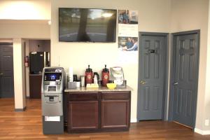 a kitchen with a counter with a drink dispenser and a refrigerator at Days Inn by Wyndham Wrightstown McGuire AFB Bordentown in Wrightstown