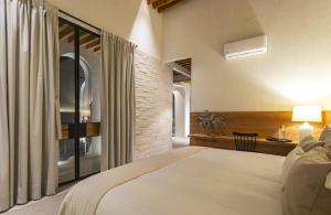 サンミゲル・デ・アジェンデにあるCasas y Suites Indigo San Miguelの大きなベッドと窓のある寝室