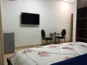 1 dormitorio con 1 cama, 2 sillas y mesa en Aseda Lodge Gh en Accra