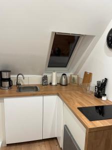 a kitchen with a sink and a tv on the wall at Deich Winde 9.2 in Dorum Neufeld