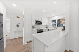 a kitchen with white cabinets and a white counter top at 542 Tarpon Pond Cottage in Seabrook Island +28 photos