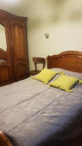 - une chambre avec un lit et 2 oreillers jaunes dans l'établissement Le Genest St Isles, à Le Genest