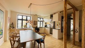 una cucina e una sala da pranzo con tavolo e sedie di ApartmentInCopenhagen Apartment 1583 a Copenaghen