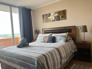 1 dormitorio con 1 cama grande y cortinas azules en Depto Estudio 1810 Centro Blanco, en Temuco