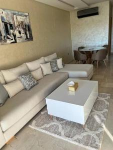 a living room with a couch and a coffee table at Beautiful apartment in Golf City Marrakech in Marrakesh