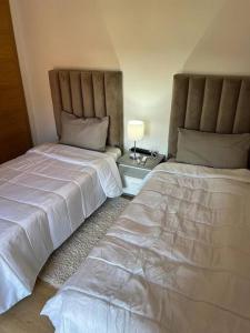 two beds sitting next to each other in a bedroom at Beautiful apartment in Golf City Marrakech in Marrakesh