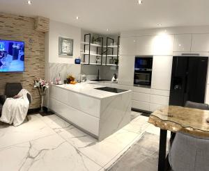 a white kitchen with a large island in the middle at Appartements-Dalila in Sankt Michael im Lungau