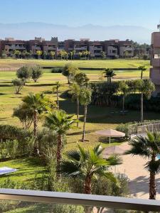 een uitzicht op een resort met palmbomen en gebouwen bij Beautiful apartment in Golf City Marrakech in Marrakesh