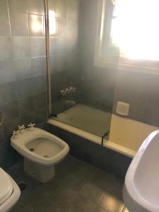 a bathroom with a toilet and a tub and a sink at Plaza San Martin Retiro in Buenos Aires