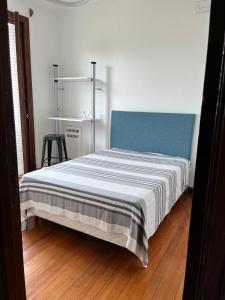 a bed with a blue headboard in a room at Plaza San Martin Retiro in Buenos Aires