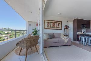 een woonkamer met een bank en een balkon bij Vistas al lago y tinaja, perfecto para familias in Puerto Varas