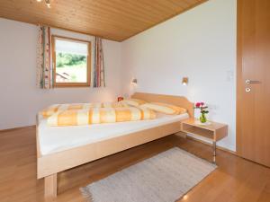 ein Schlafzimmer mit einem großen Bett und einem Fenster in der Unterkunft Appartement Moosbrugger Haus Elisabeth in Schoppernau