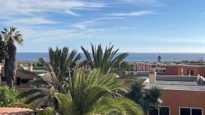 uma vista para uma cidade com palmeiras e o oceano em La Casita de Bonnie em La Tejita