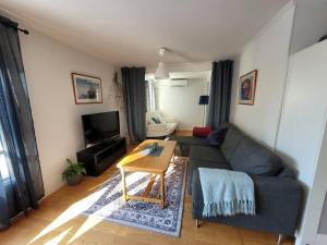 a living room with a couch and a table at Trevligt hus/stuga i Svärtinge in Norrköping