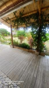 an outdoor patio with a wooden floor and plants at Cabaña Riviera Pacific in Pedernales