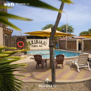 a pool with chairs and umbrellas in front of a resort at Huluwaju Hotel in La Bocana