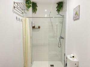 a white bathroom with a shower and a toilet at ☆The Central Valencia Stay☆ in Valencia +20 photos