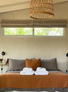 ein Bett mit Handtüchern darüber mit Fenster in der Unterkunft Las Quimeras in Nono
