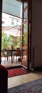 Une porte ouverte s'ouvre sur une terrasse avec une table et un parasol. dans l'établissement Jardin secreto en el centro de Barcelona 2, à Barcelone