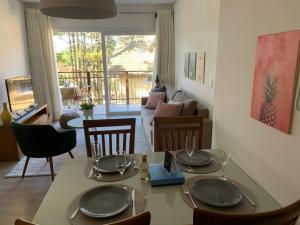 une salle à manger avec une table et des chaises et un salon dans l'établissement APTO C/PISCINA AQUECIDA! Vc vai se surpreender!, à Gramado 11 autres photos