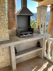 a stone fireplace with a stove on a patio at Villa Víctor in Cómpeta
