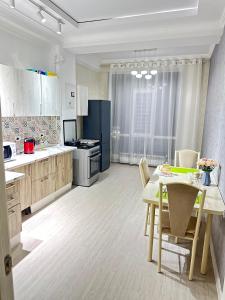 een keuken met een tafel en stoelen en een eetkamer bij Elizavetta in Bisjkek