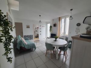 uma cozinha e sala de estar com mesa e cadeiras em Maisonnette abj em Anneyron